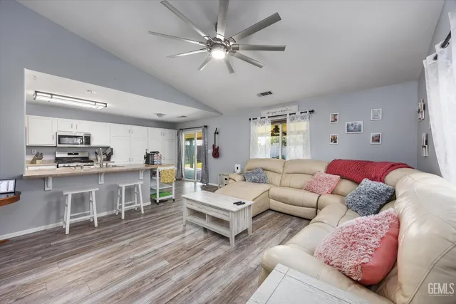 a living room with furniture and view of kitchen