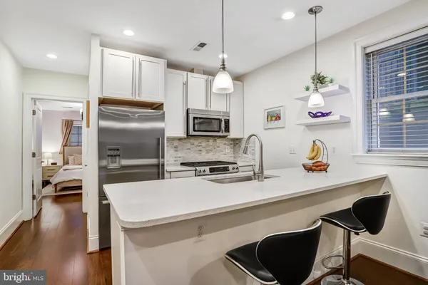 a kitchen with a refrigerator and a stove top oven