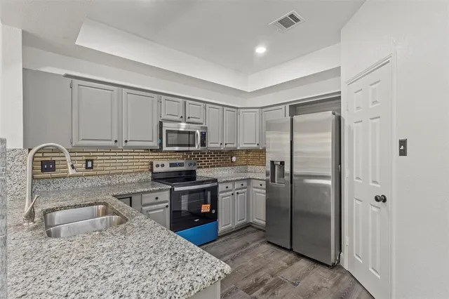 an empty room with wooden floor closet and windows