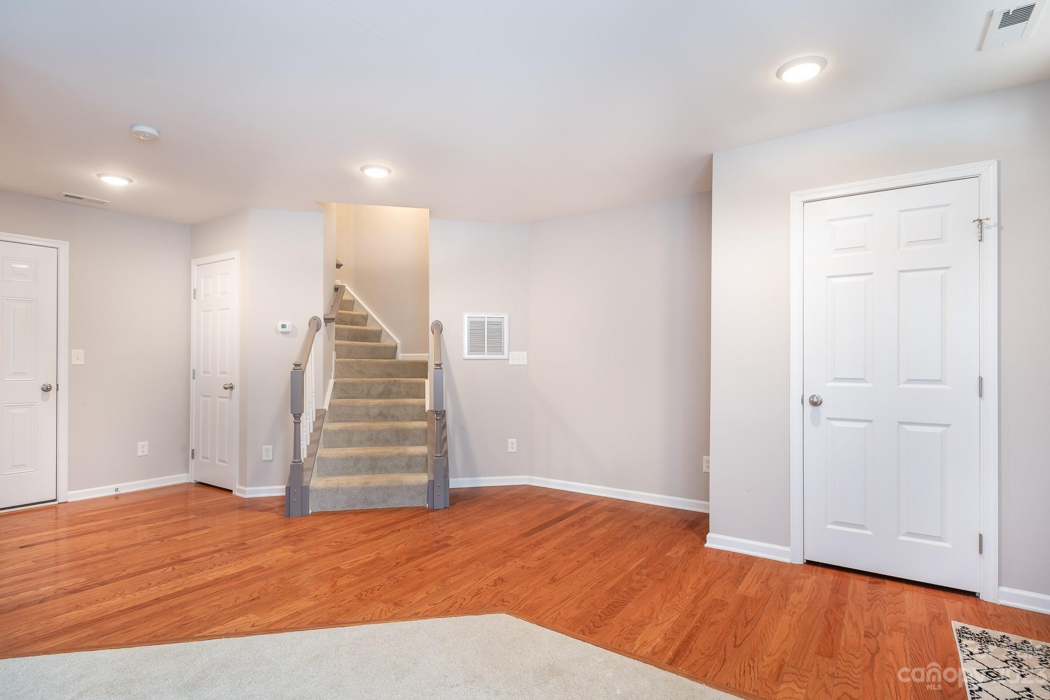 725 Naramore Street Davidson, NC 28036 - Photo 21 of 27 a view of an empty room with wooden floor and stairs