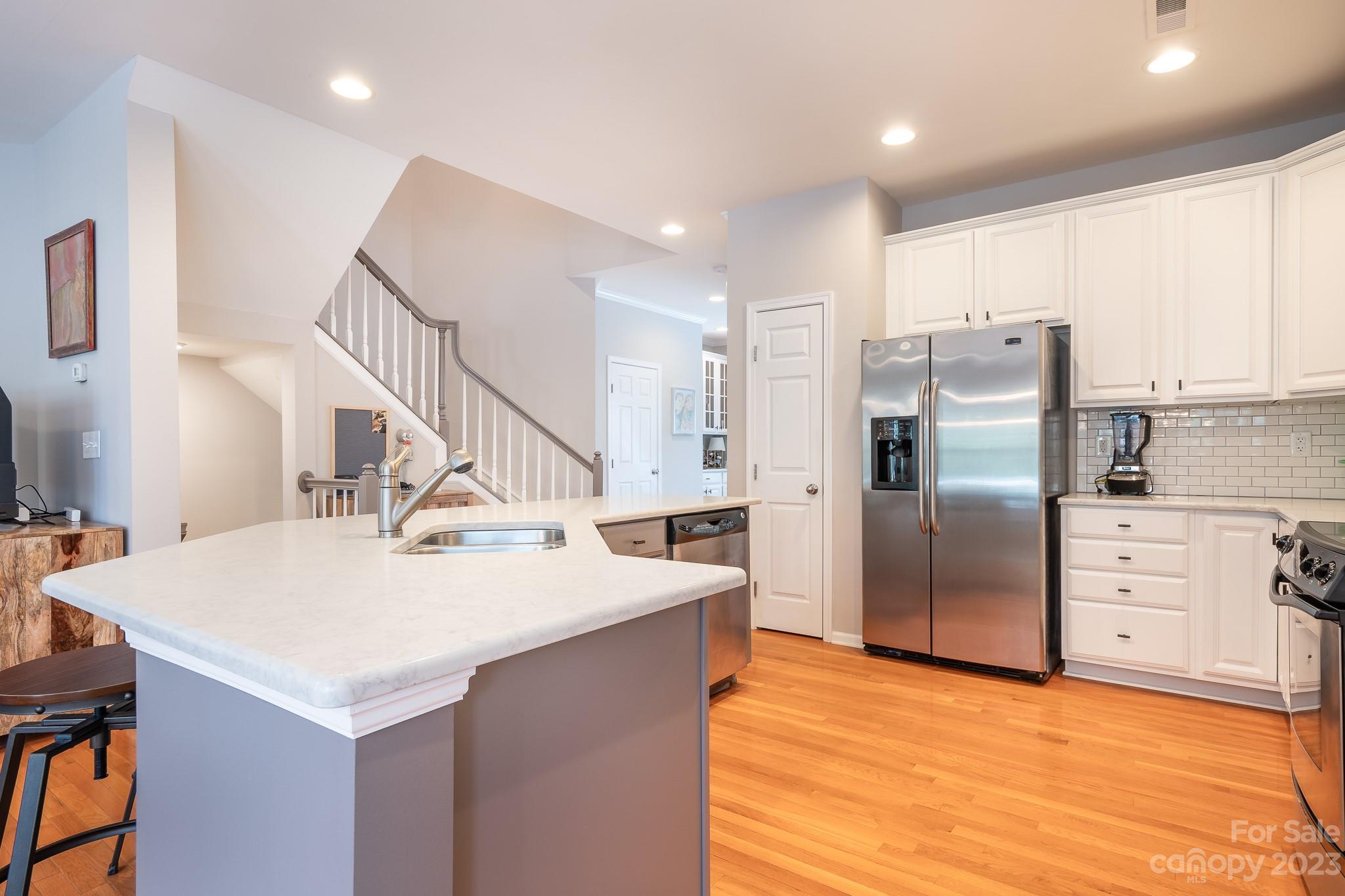 725 Naramore Street Davidson, NC 28036 - Photo 5 of 27 a kitchen with stainless steel appliances kitchen island a refrigerator sink and cabinets
