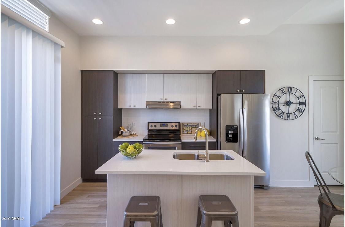 2015 North 50th Street, Unit 44 Phoenix, AZ 85008 - Photo 4 of 17 a kitchen that has a refrigerator a stove a sink and a dining table with wooden floor