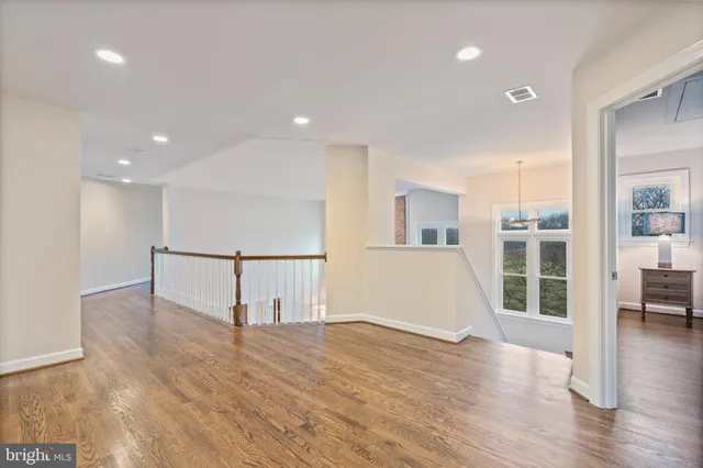 a living room with stainless steel appliances kitchen island a fireplace wooden floor and living room view