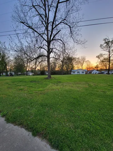 a backyard of a house with lots of green space and fountain