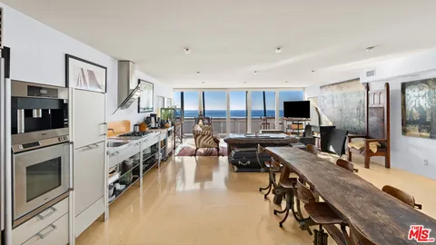 a kitchen with a table chairs microwave and cabinets