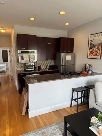 a kitchen with a sink cabinets and wooden floor
