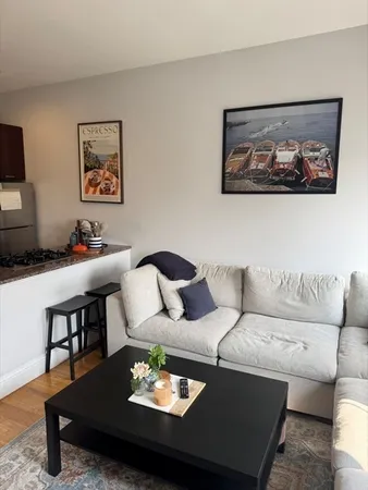 a living room with furniture a rug and a flat screen tv