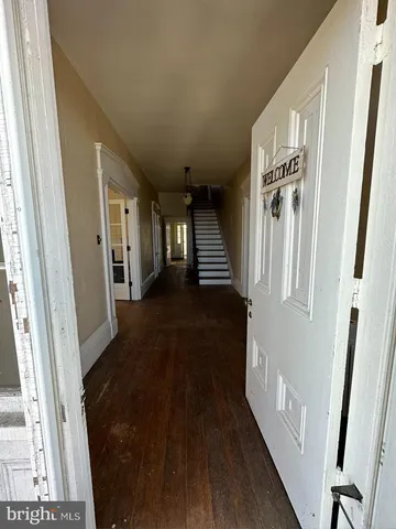 a view of a hallway with entryway wooden floor and front door
