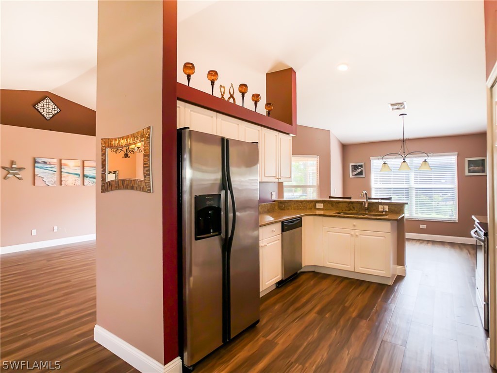 9068 Morris Road Fort Myers, FL 33967 - Photo 14 of 29 a kitchen with stainless steel appliances granite countertop a refrigerator a stove and a wooden floors