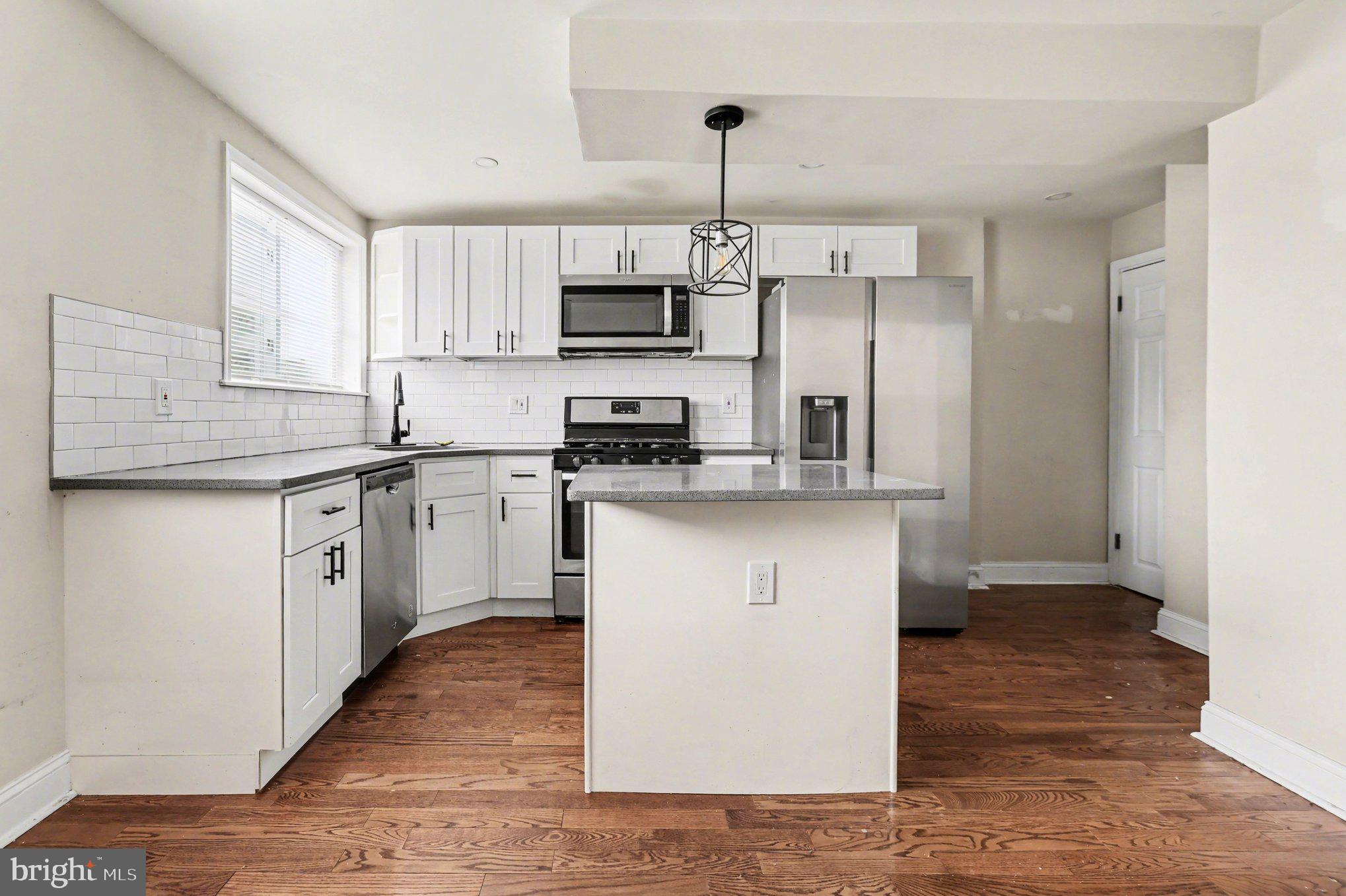 798 Bennington Road Folcroft, PA 19032 - Photo 8 of 28 a kitchen with stainless steel appliances granite countertop a sink a stove a refrigerator and white cabinets