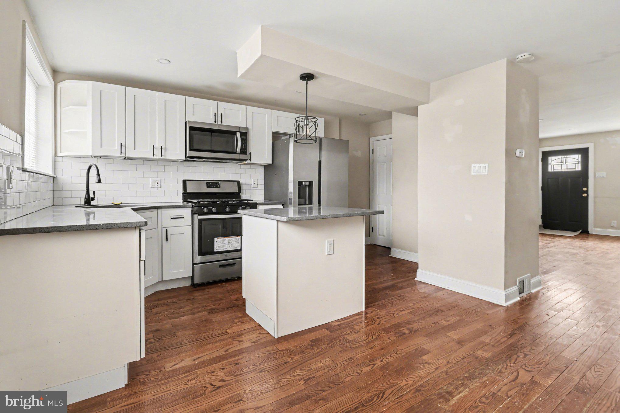 798 Bennington Road Folcroft, PA 19032 - Photo 9 of 28 a kitchen with stainless steel appliances granite countertop a stove top oven a refrigerator a sink and dishwasher with wooden floor