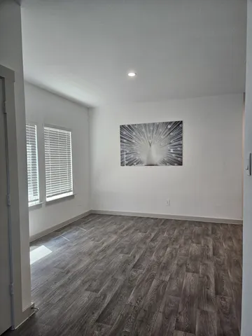 a view of empty room with wooden floor