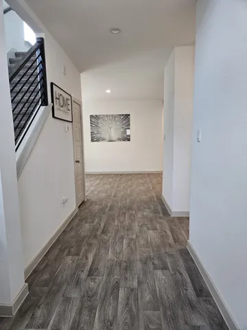 a view of a hallway with wooden floor