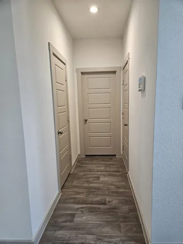 a view of a hallway with wooden floor