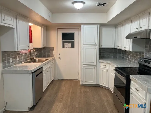 an empty room with wooden floor and entrance