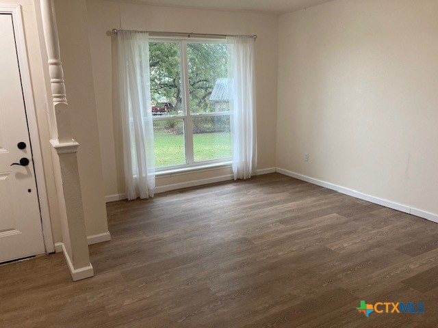 2603 West Main Street Cameron, TX 76520 - Photo 8 of 26 an empty room with wooden floor and windows