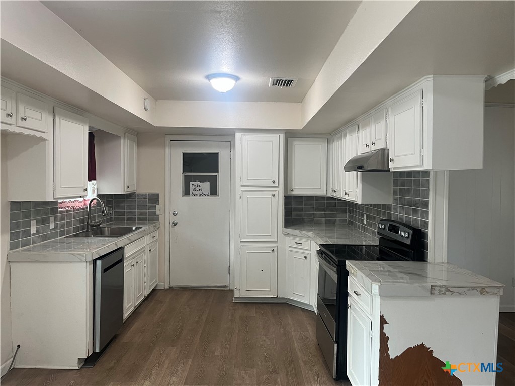 2603 West Main Street Cameron, TX 76520 - Photo 9 of 26 a kitchen with a sink stove top oven and refrigerator