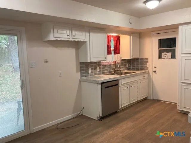 a kitchen with a sink cabinets appliances and a window