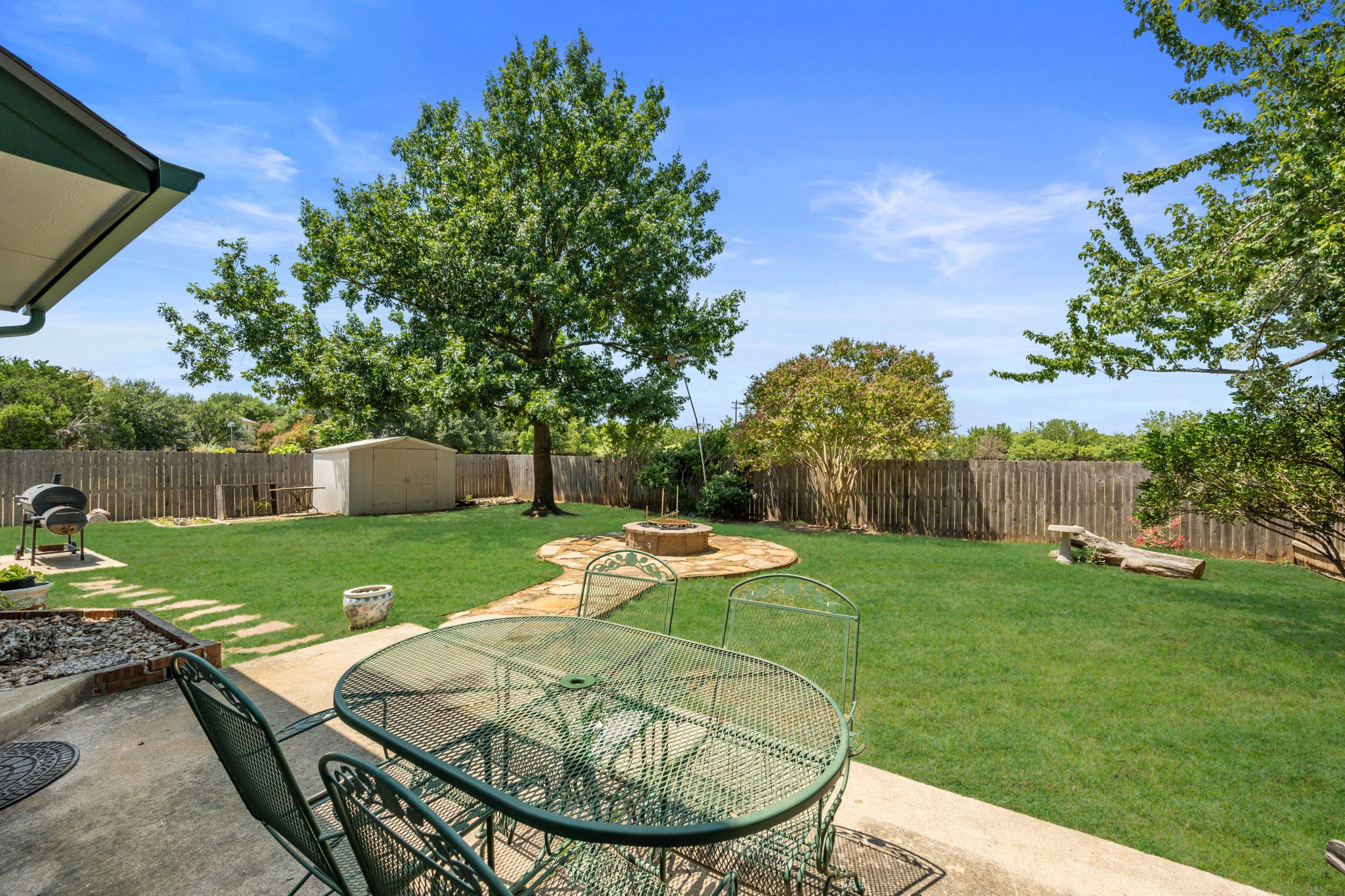 2440 Madeline Loop Cedar Park, TX 78613 - Photo 32 of 33 Fenced backyard with outdoor dining area, a patio, a storage unit, and a fire pit