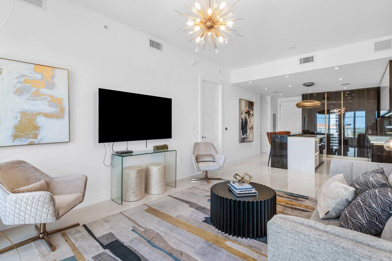 155 East Boca Raton Road, Unit 919 Boca Raton, FL 33432 - Photo 11 of 45 a living room with furniture and a flat screen tv