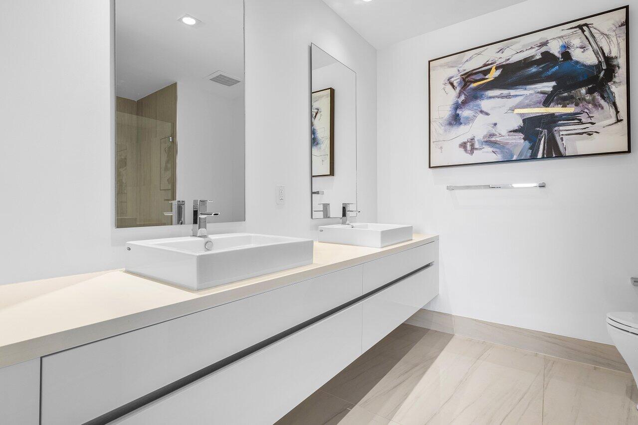 155 East Boca Raton Road, Unit 919 Boca Raton, FL 33432 - Photo 13 of 45 a bathroom with a double vanity sink and a mirror