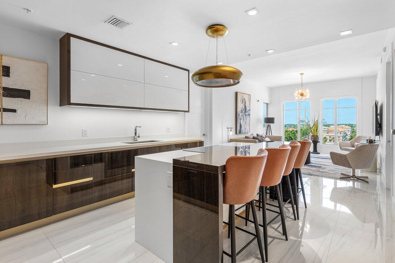 155 East Boca Raton Road, Unit 919 Boca Raton, FL 33432 - Photo 4 of 45 a kitchen with stainless steel appliances kitchen island granite countertop a table chairs sink and cabinets