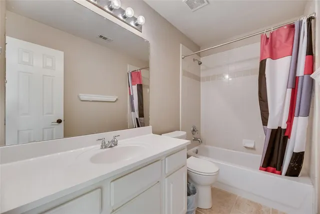 a bathroom with a sink a toilet and a large mirror