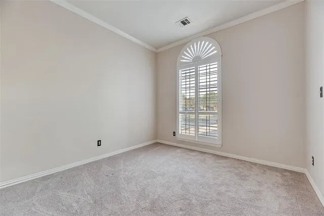 an empty room with windows and chandelier fan