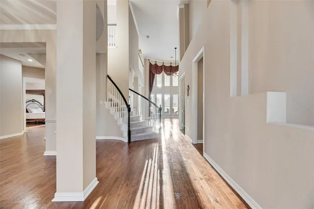 a view of a hallway with wooden floor and staircase