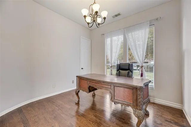 a dining room with wooden floor and a chandelier