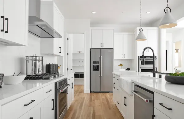 a kitchen with white cabinets and appliances