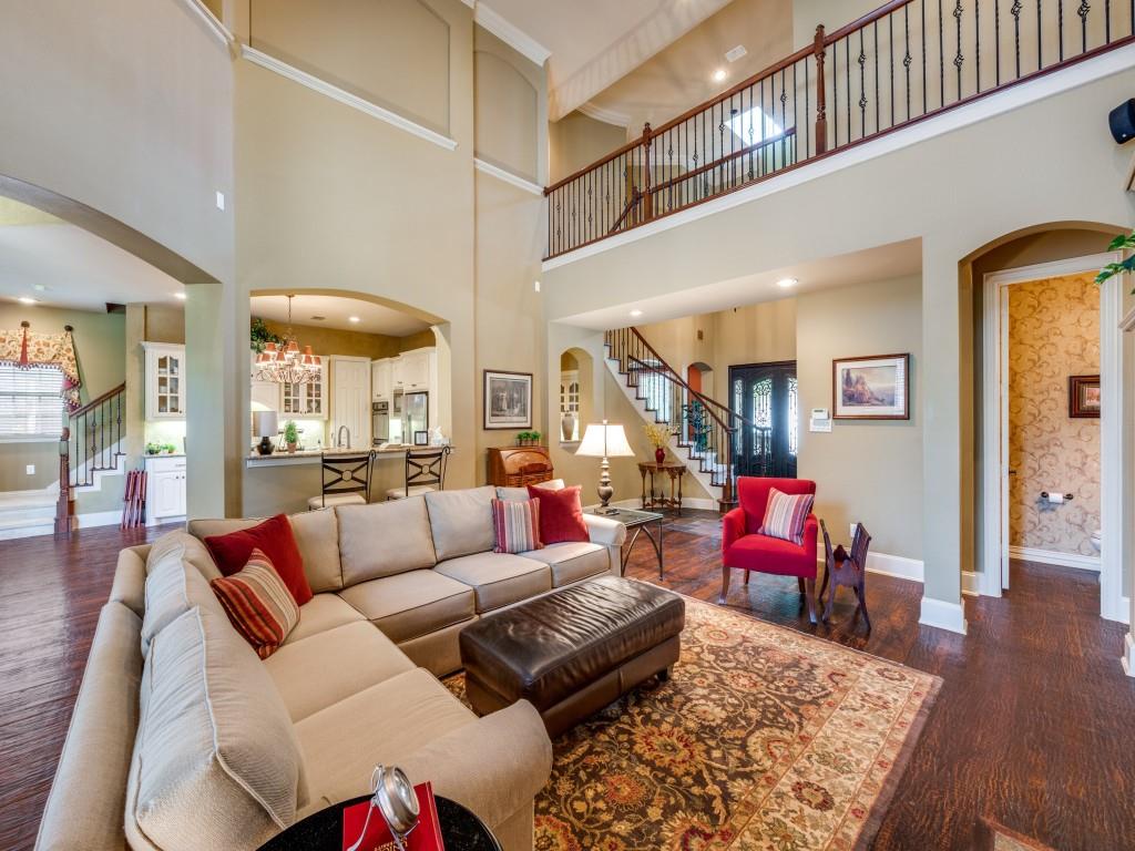 6470 Hunters Parkway Frisco, TX 75035 - Photo 13 of 40 Living area featuring stairs, arched walkways, dark wood-style flooring, a chandelier, and a towering ceiling