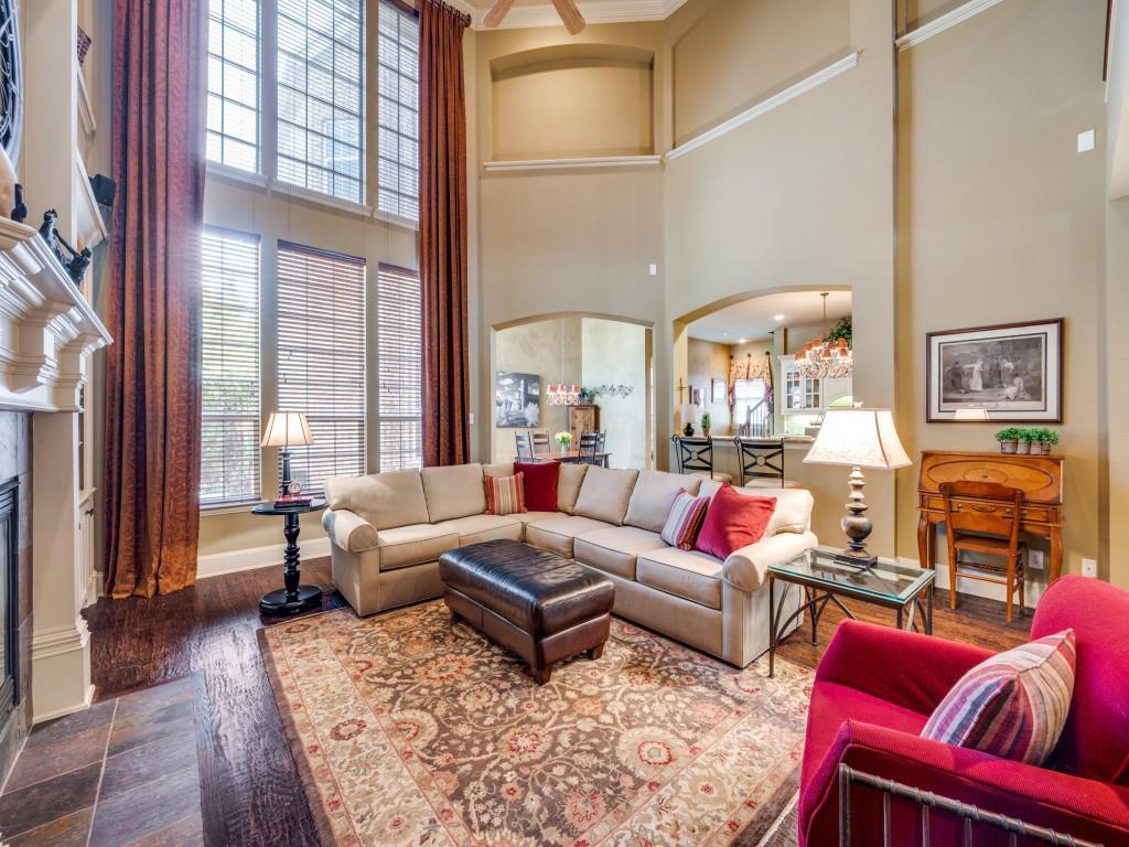 6470 Hunters Parkway Frisco, TX 75035 - Photo 6 of 40 Living area featuring arched walkways, dark wood-type flooring, a fireplace, a high ceiling, and ornamental molding