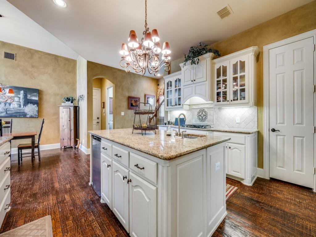6470 Hunters Parkway Frisco, TX 75035 - Photo 7 of 40 Kitchen with glass insert cabinets, white cabinetry, a center island with sink, tasteful backsplash, and hanging light fixtures