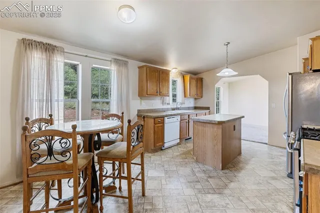 a kitchen with granite countertop a sink stove and refrigerator