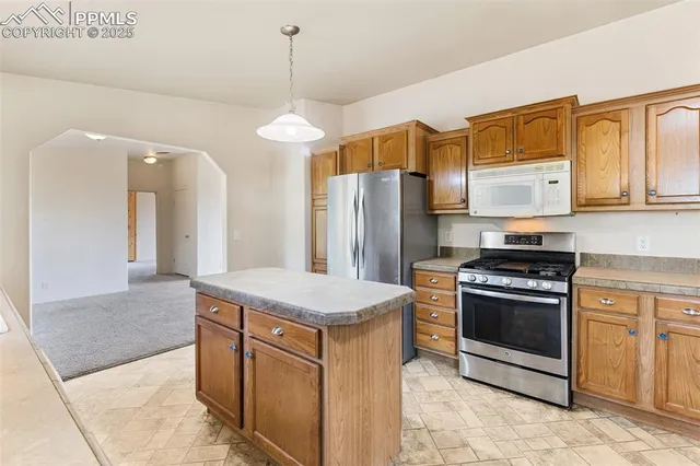 a kitchen with stainless steel appliances granite countertop a stove a chimney a sink and a refrigerator