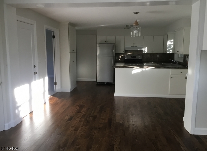 1 Union Avenue, Unit 3 Madison, NJ 07940 - Photo 4 of 12 a view of a kitchen with a fridge and wooden floor