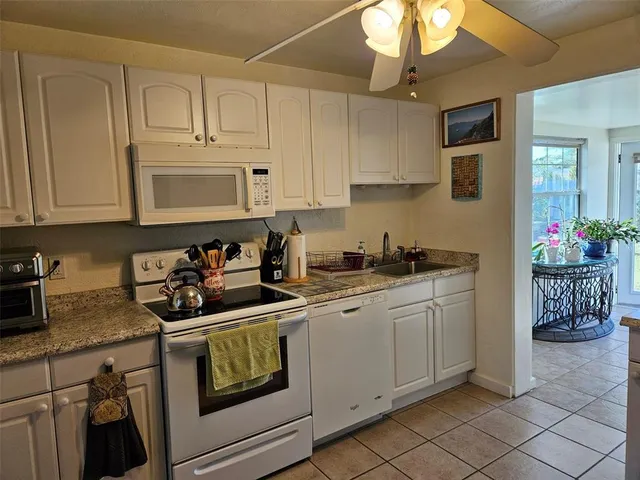 a kitchen with white cabinets and sink