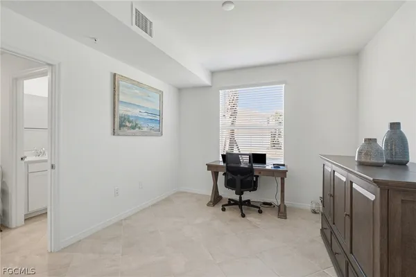 a view of a workspace with furniture and a window