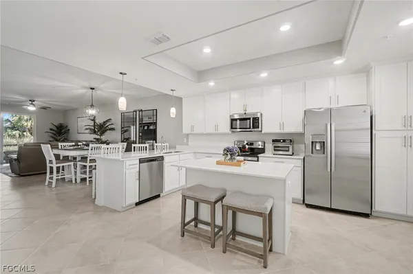 a kitchen with white cabinets and stainless steel appliances