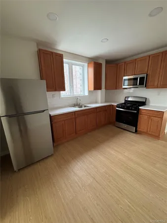 a large kitchen with stainless steel appliances granite countertop a refrigerator and a stove top oven