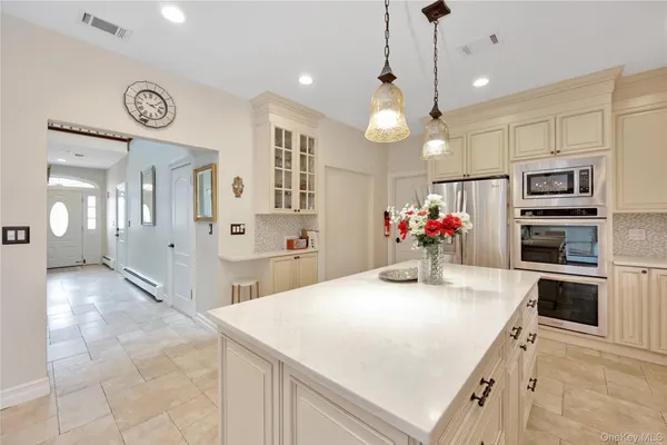 a kitchen with stainless steel appliances kitchen island granite countertop a stove a sink and a refrigerator