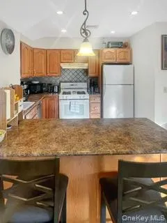 a kitchen with kitchen island granite countertop a stove and a sink