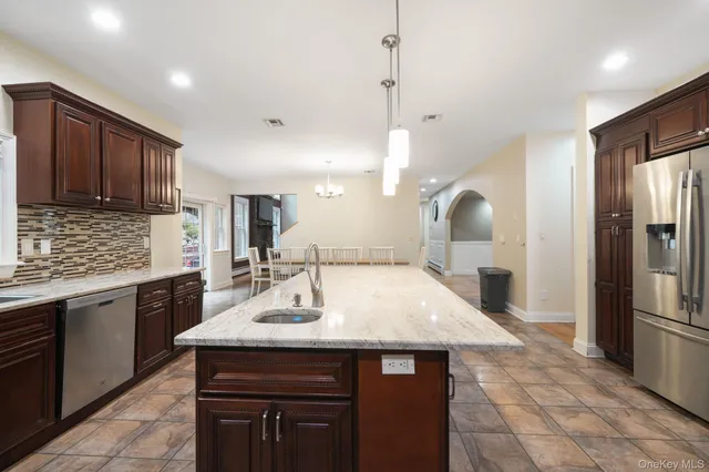 a kitchen with kitchen island a sink appliances and cabinets