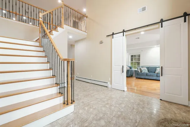 a view of entryway and hall with wooden floor