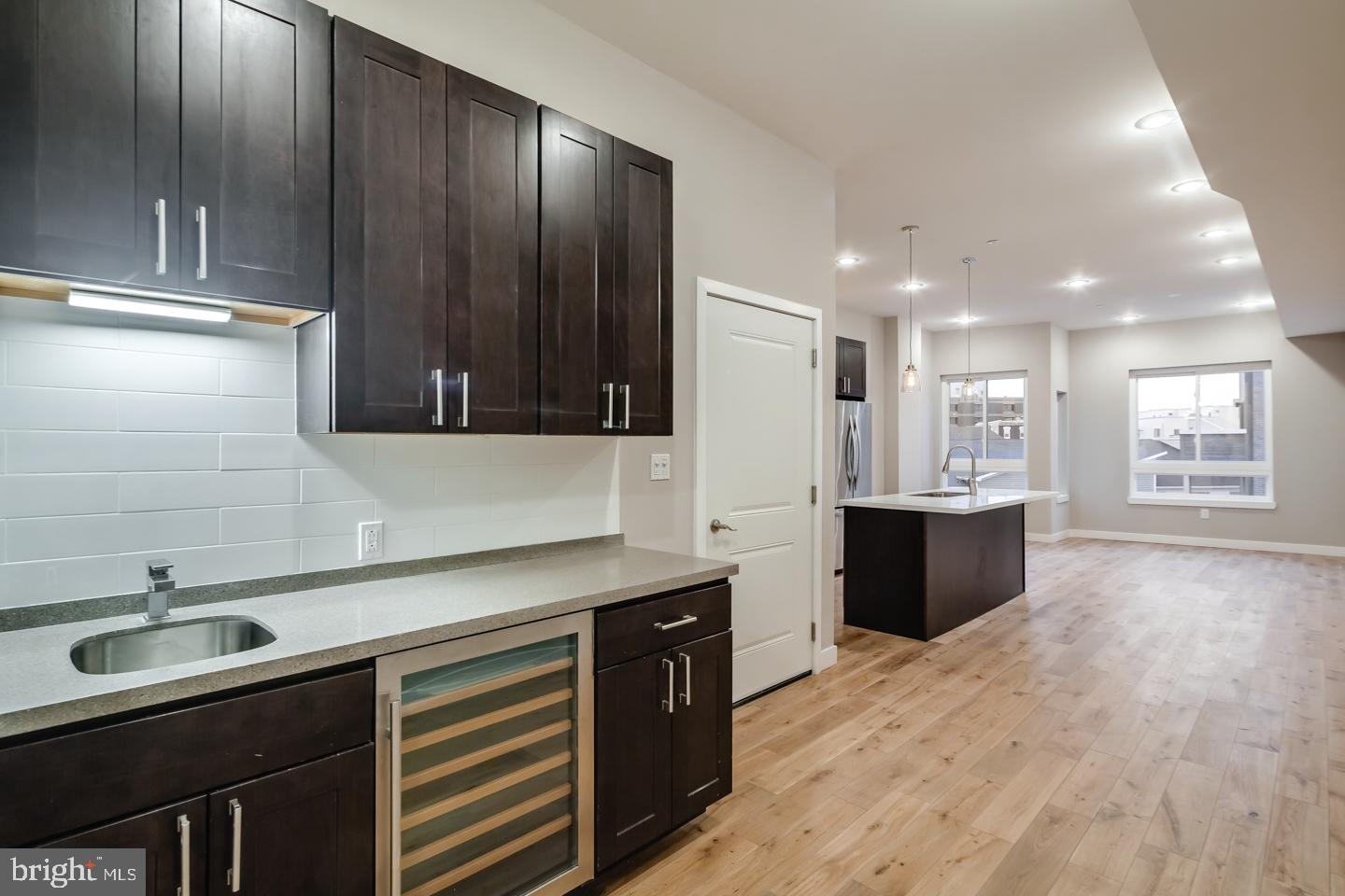 1636 Ridge Avenue, Unit PH Philadelphia, PA 19130 - Photo 5 of 16 a kitchen with stainless steel appliances granite countertop a sink a stove and a wooden floors