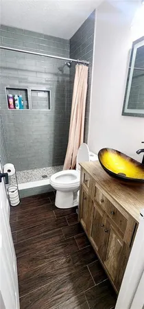a bathroom with a sink mirror vanity and toilet