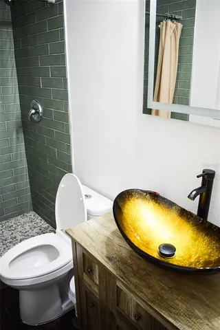 a bathroom with a granite countertop toilet sink and mirror