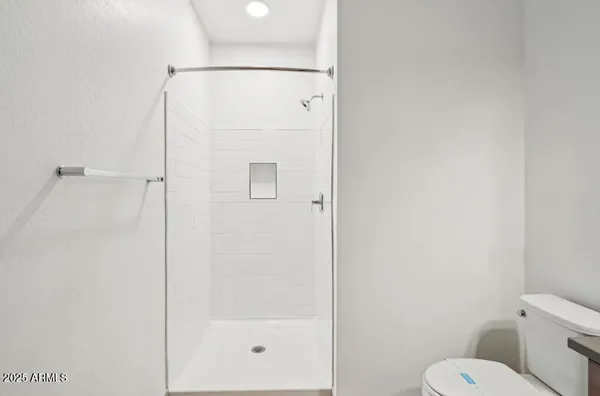 a bathroom with a shower a toilet and a mirror
