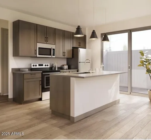 a living room with stainless steel appliances furniture and a kitchen view